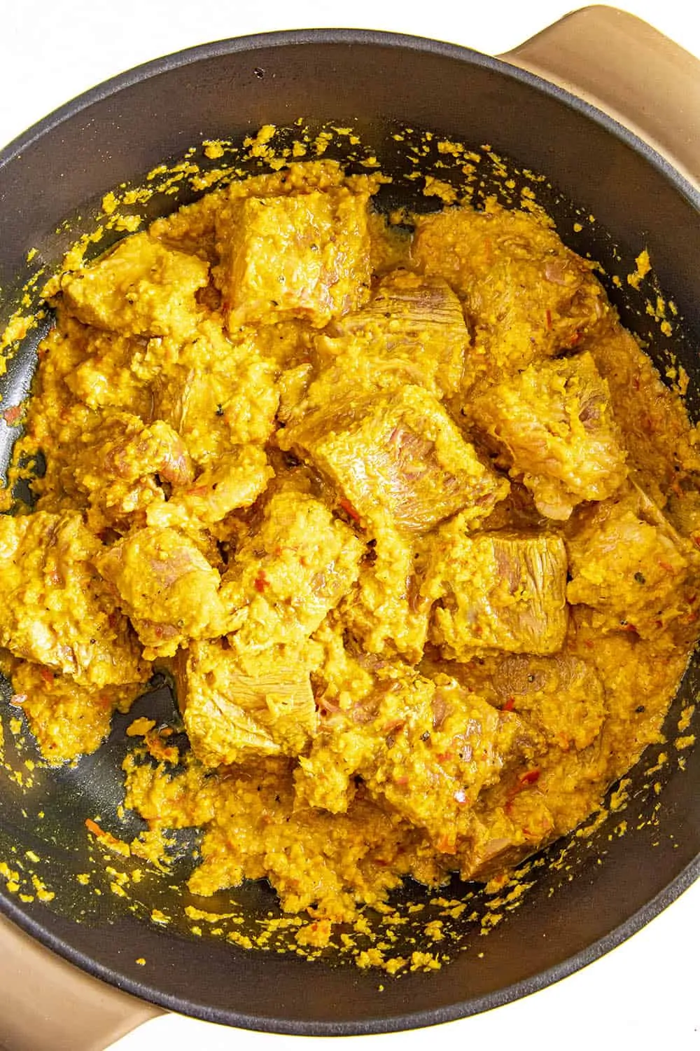 Browning the beef with the rendang curry mixture in a large pot
