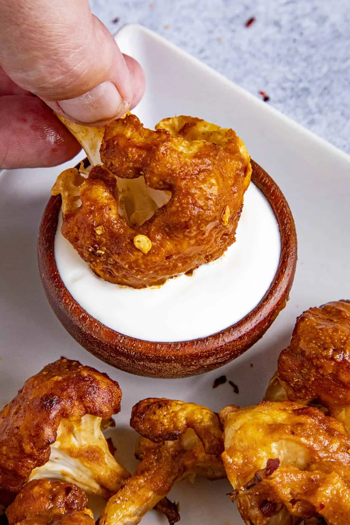 Dipping a piece of buffalo cauliflower into blue cheese dip