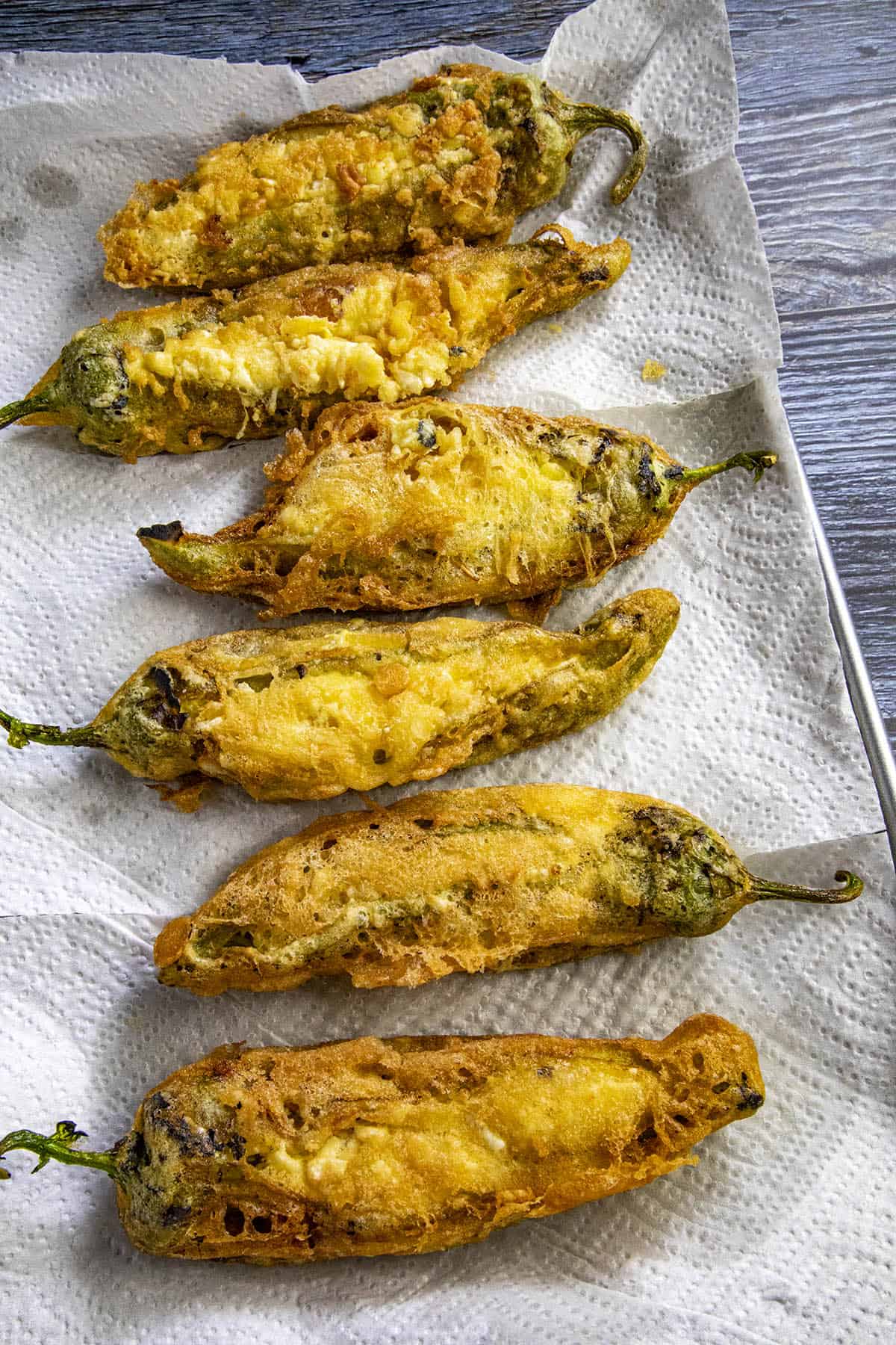 Chiles rellenos just out of the fryer, draining on paper towels
