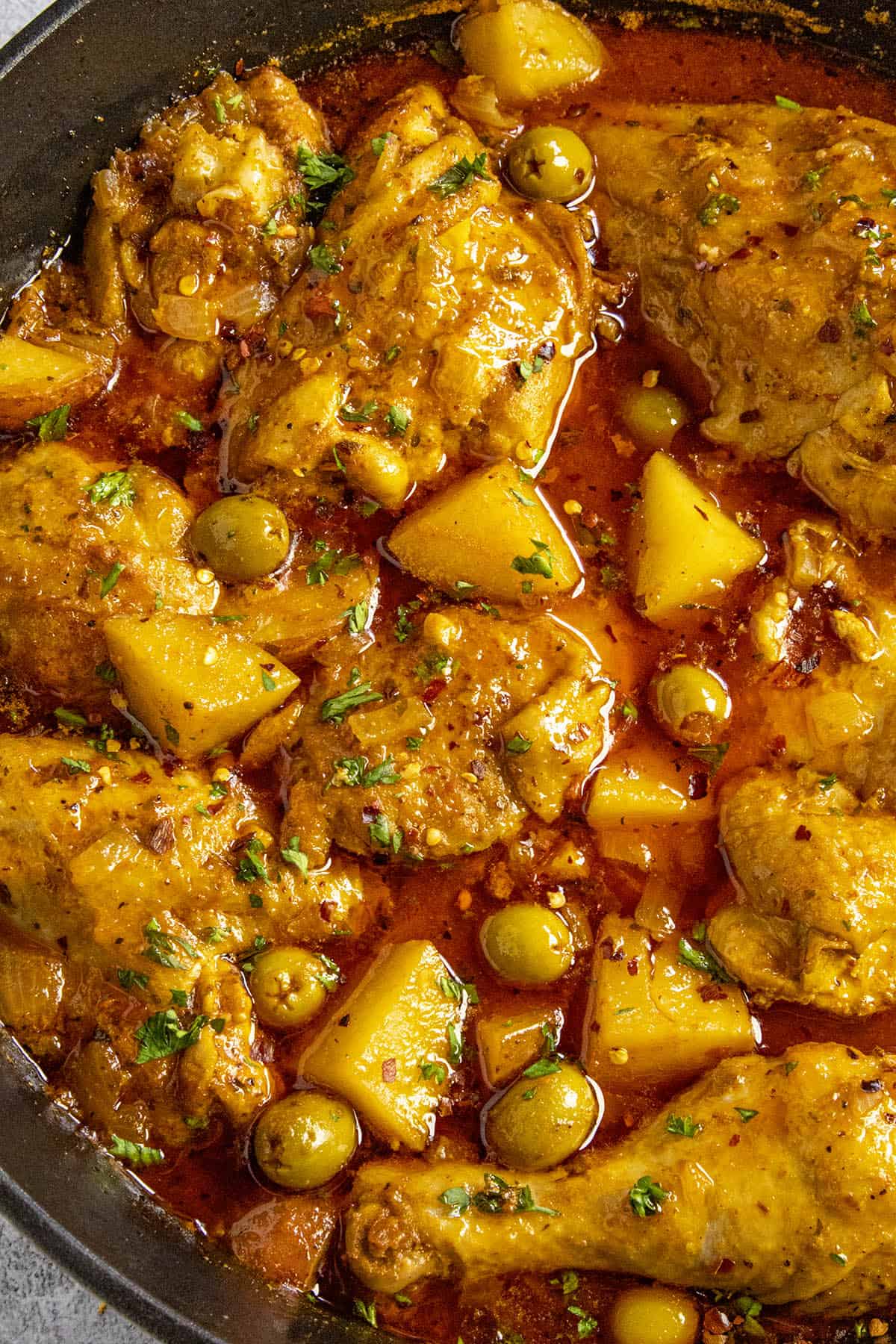 Pollo Guisado Recipe (Chicken Stew) in a pot with lots of potatoes and olives