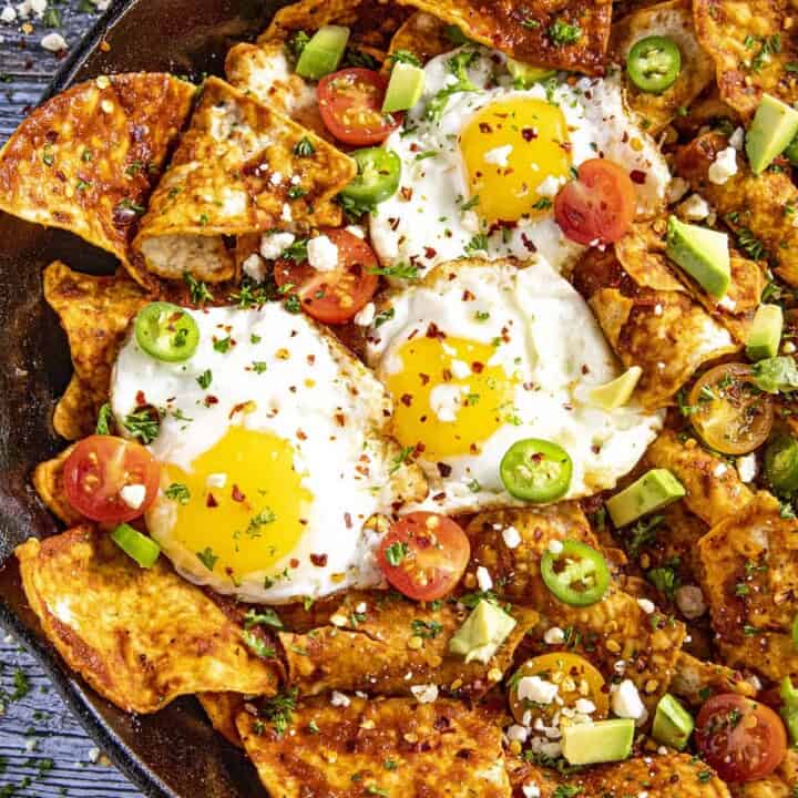 Mike serving up A pan full of Chilaquiles Rojos with fried eggs on top