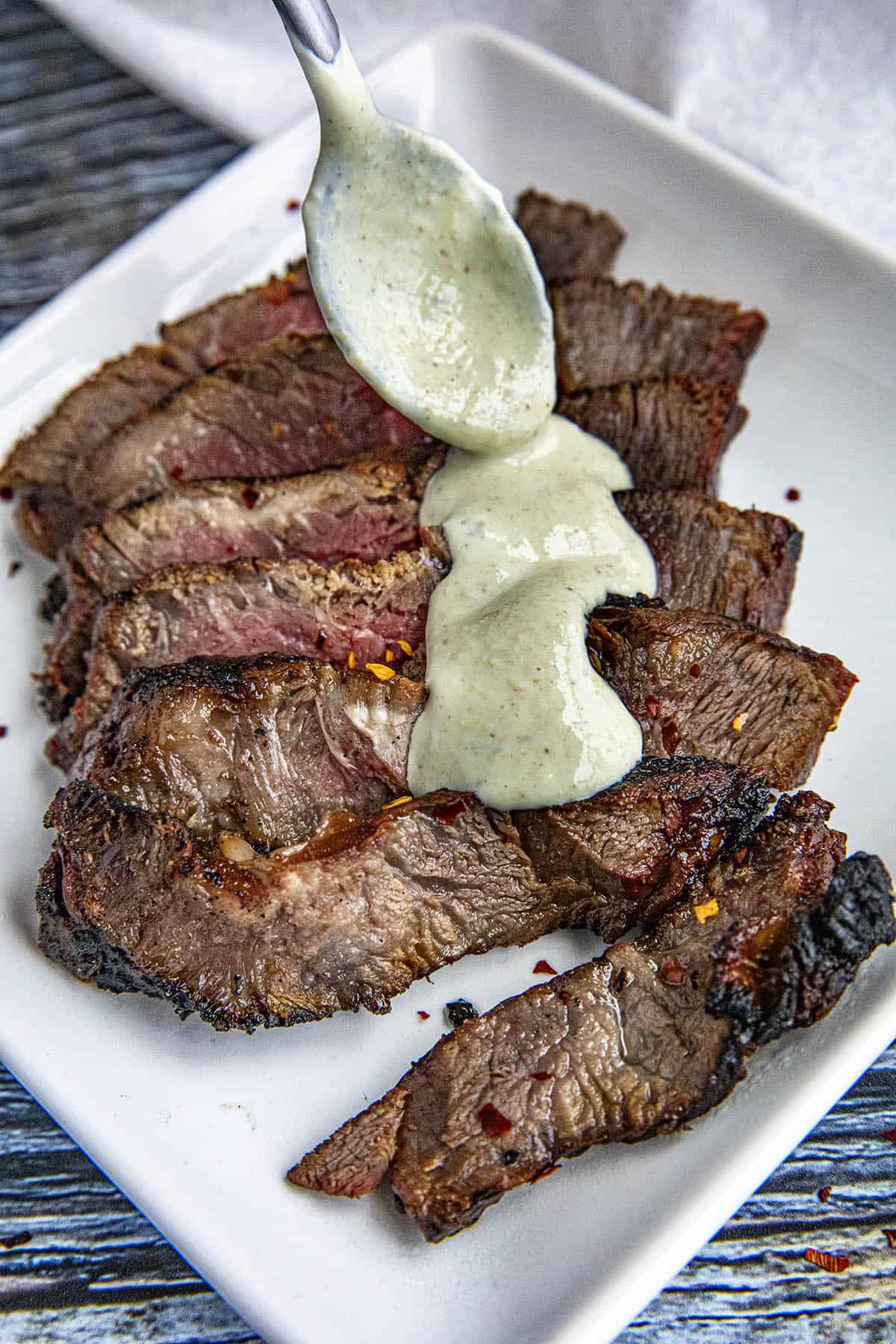 Horseradish Cream Sauce being poured over steak