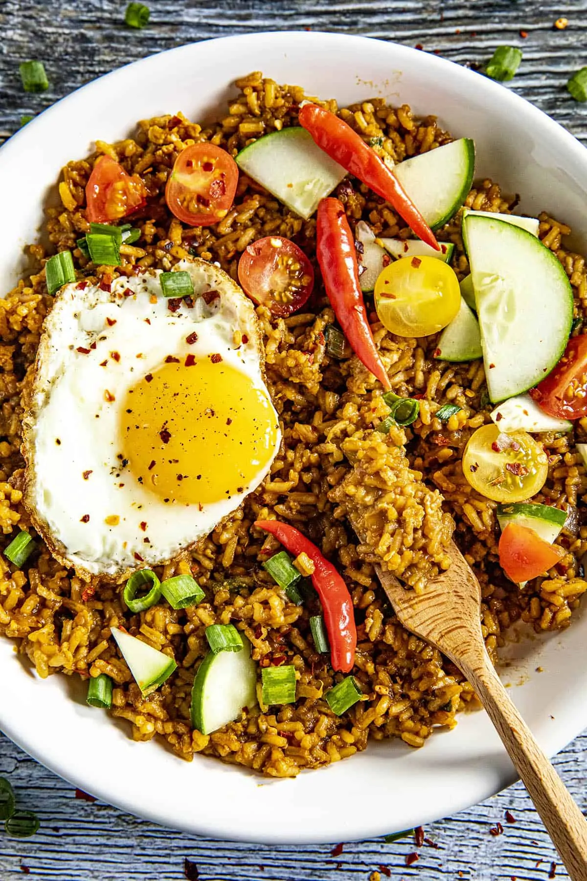Taking a forkful of Indonesian Fried Rice (Nasi Goreng) from a bowl