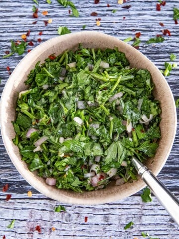 Chimichurri served in a big bowl with a spoon inside the bowl.