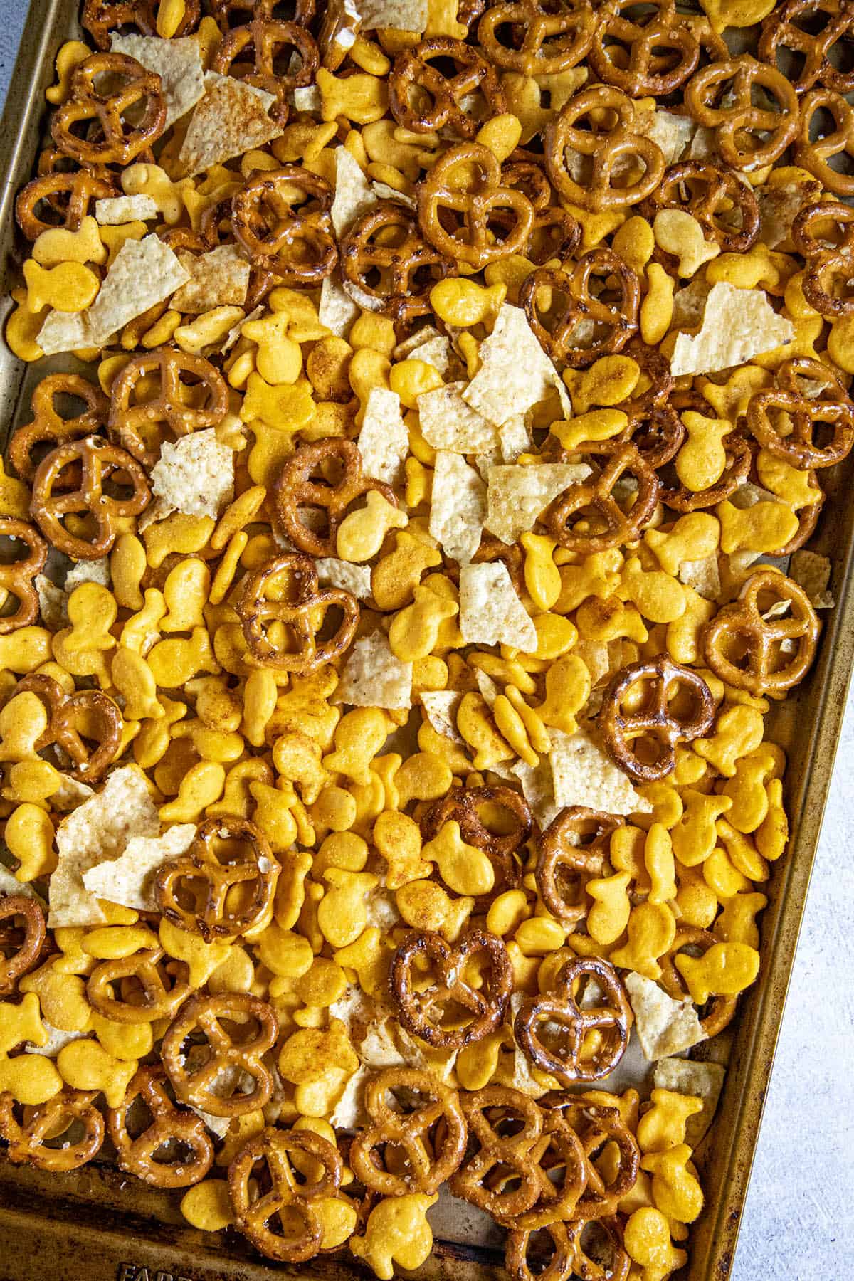 Homemade Spicy Snack Mix on a baking sheet, ready for the oven.