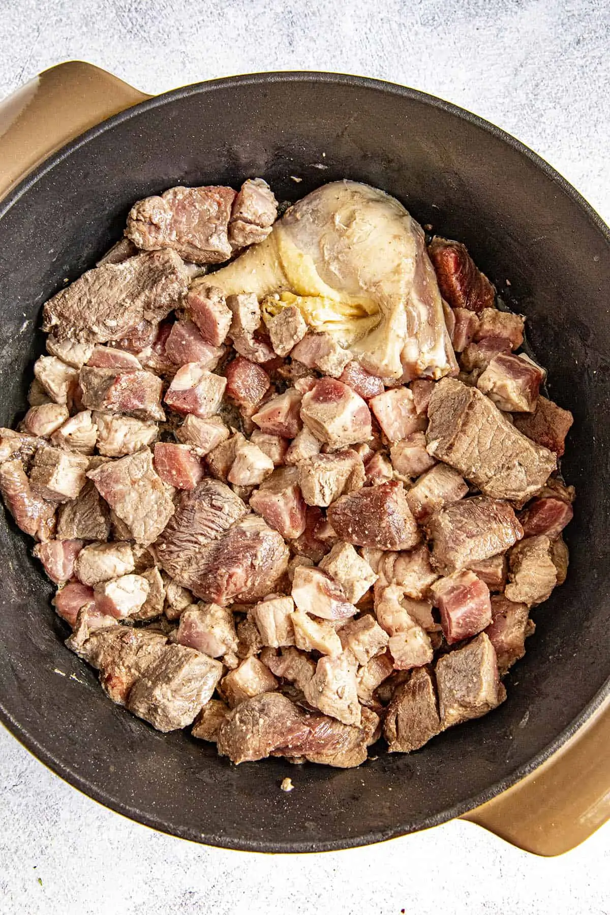 Browning meats in a pot to make burgoo stew