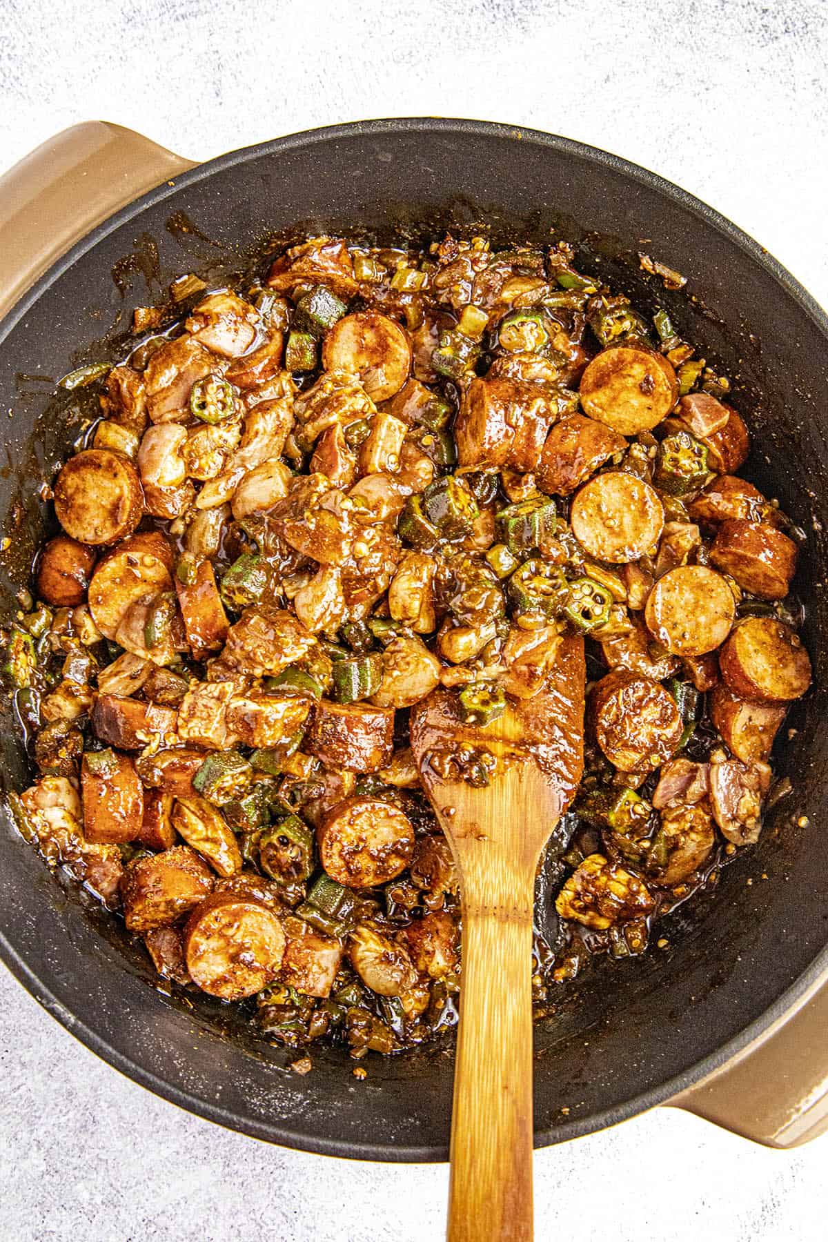 Stirring the Chicken and Sausage into the pot of gumbo