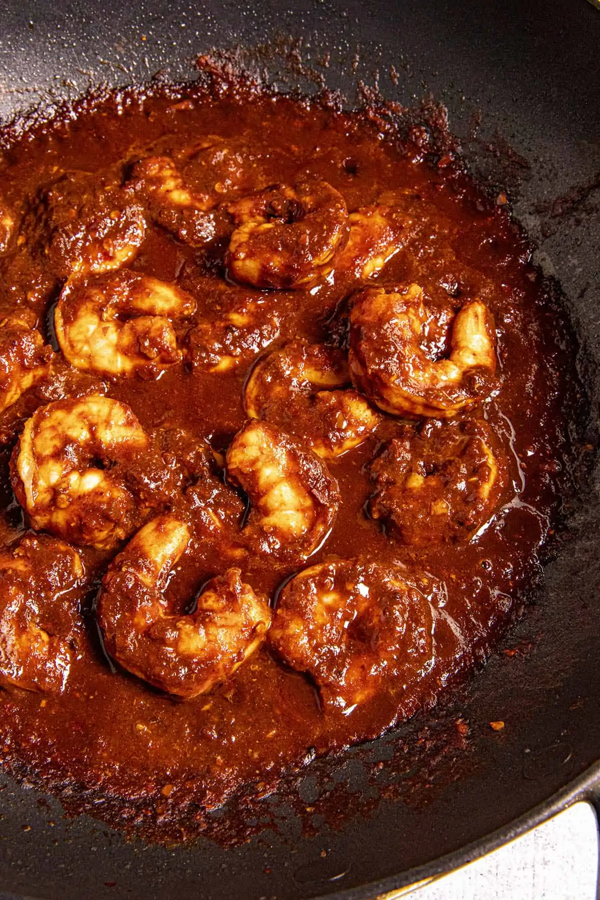 Camarones a la Diabla (Diablo Shrimp) simmering in a pan with spicy sauce