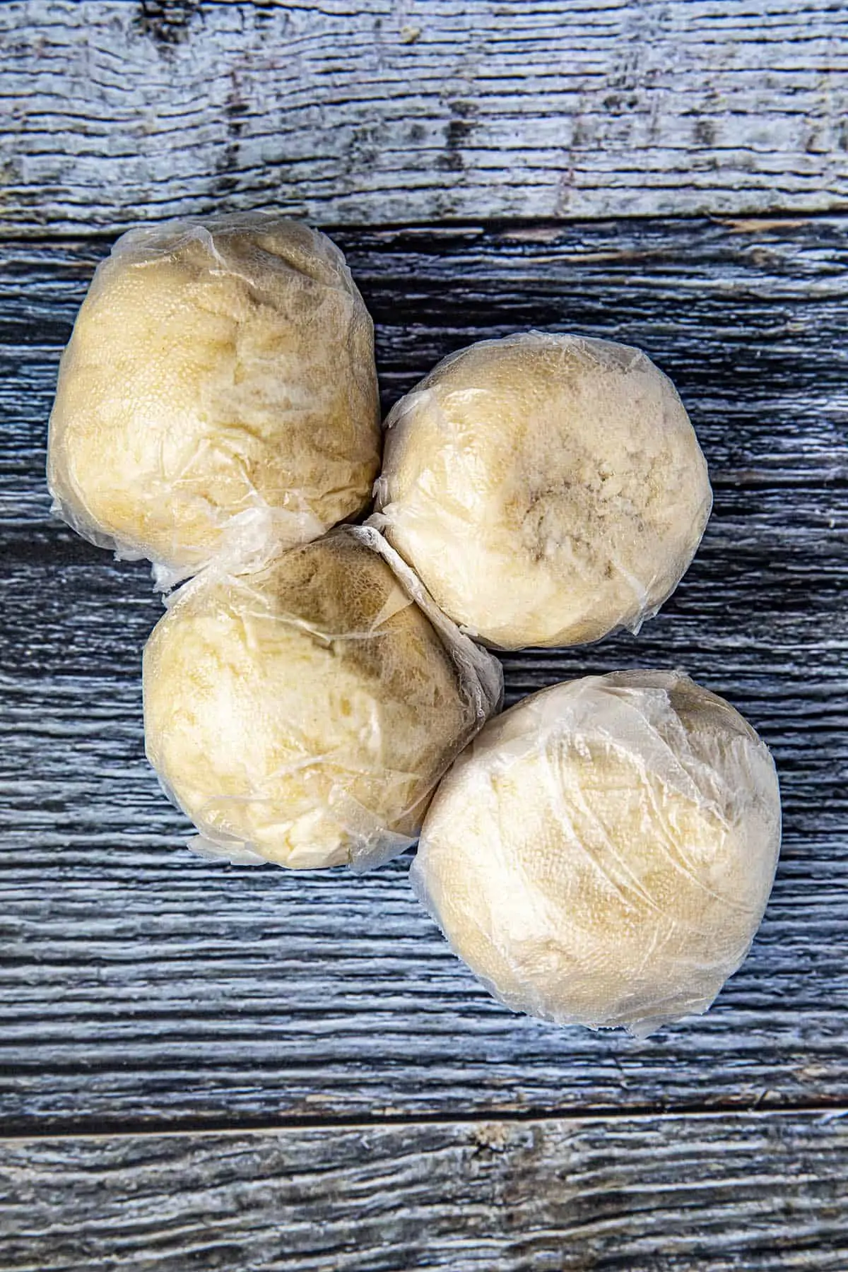 Flatbread dough wrapped in plastic wrap.