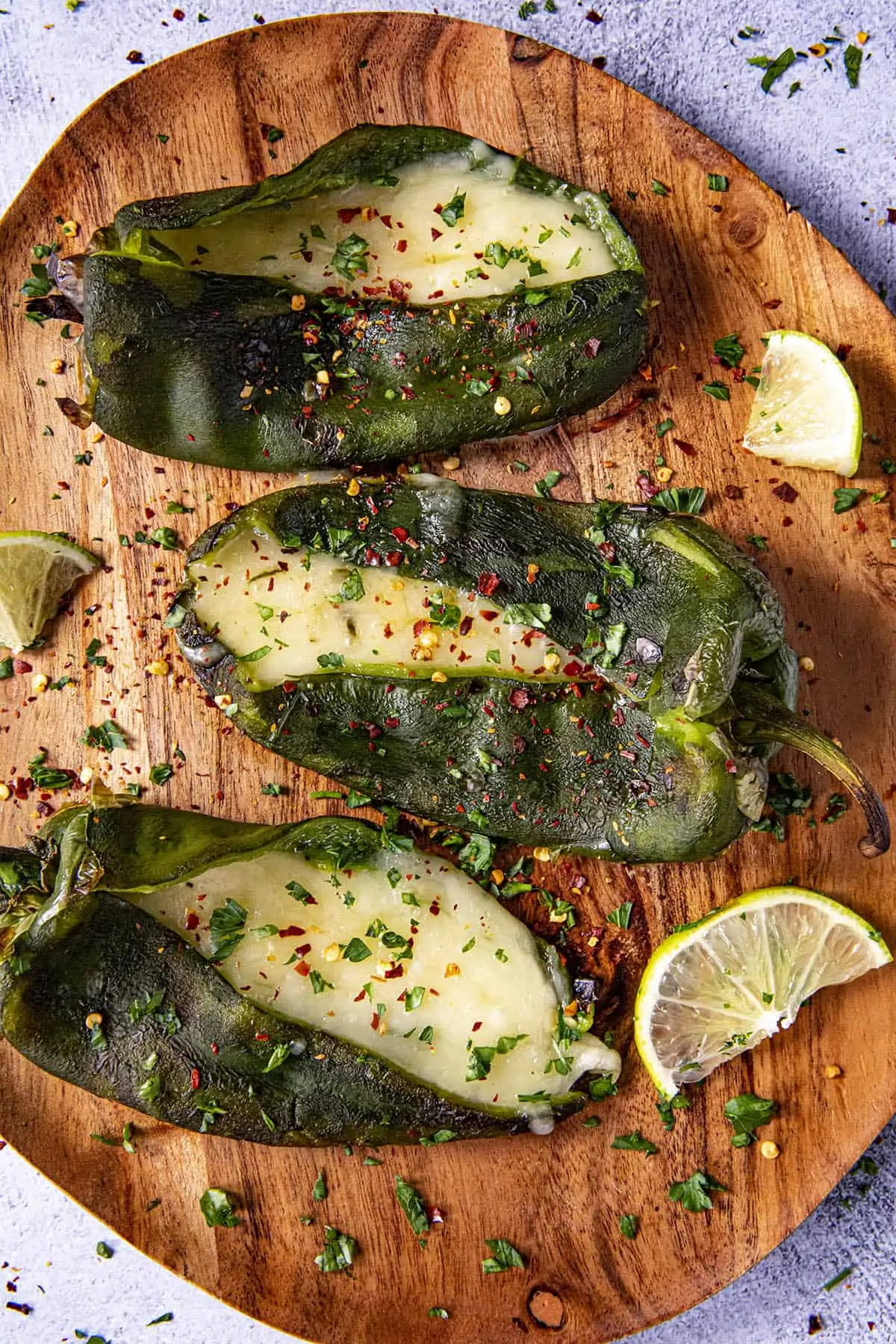 Three Poblano peppers stuffed with cheese on a plate
