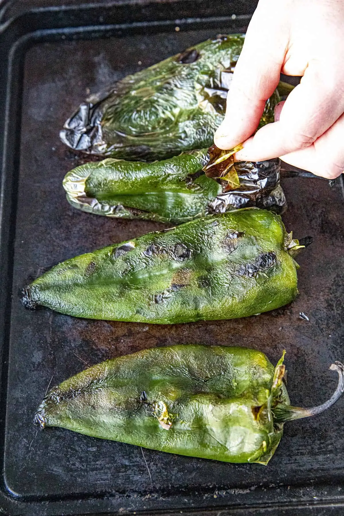 Peeling the grilled poblano peppers