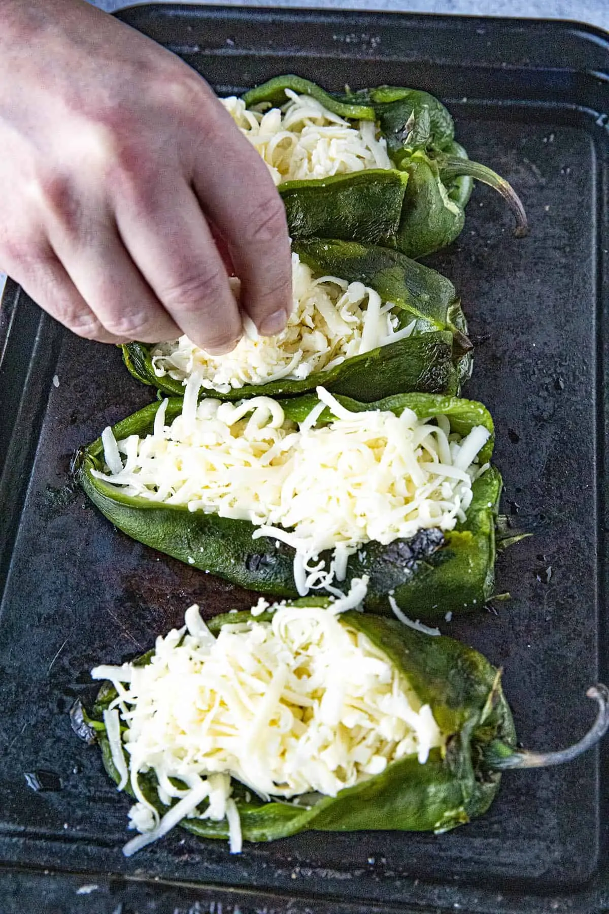Stuffing roasted poblano peppers with cheese