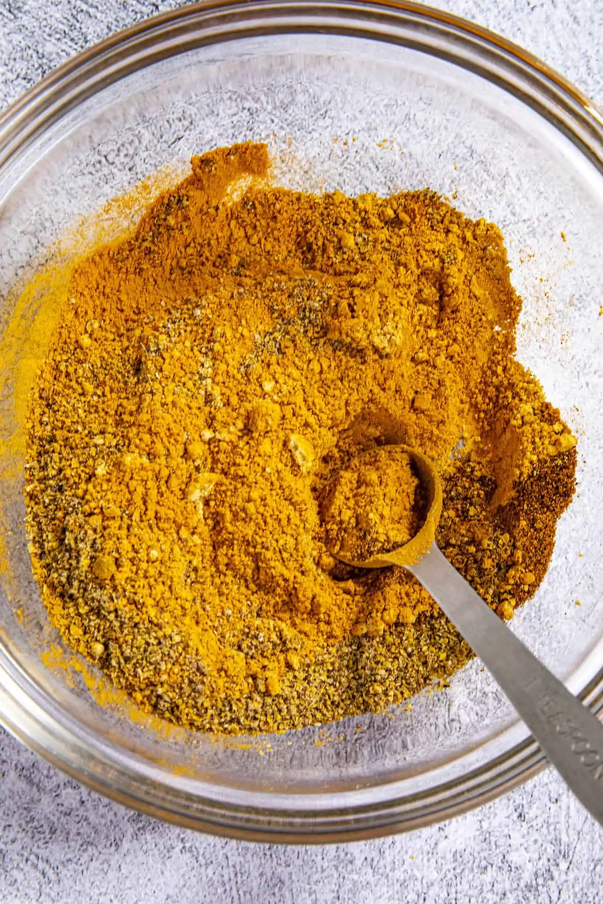 Mixing Jamaican Curry Powder ingredients in a bowl.