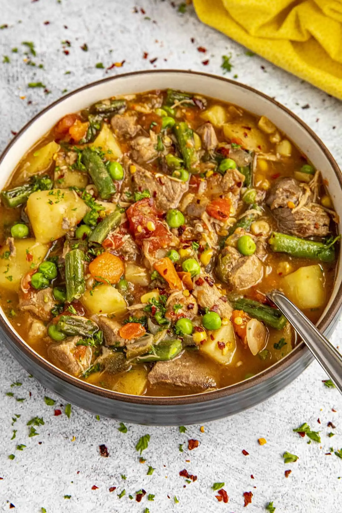 Chunky booyah stew in a bowl with a spoon