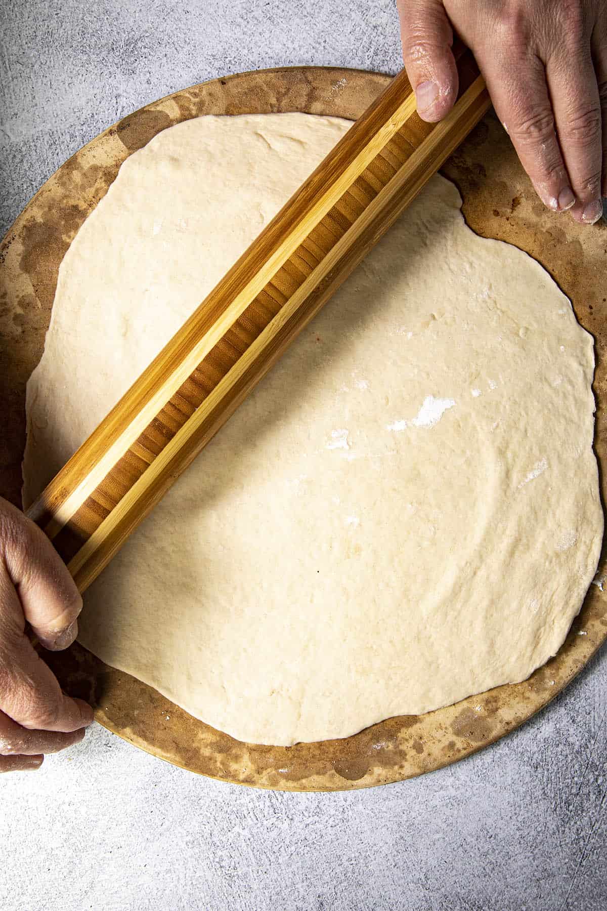 Rolling out pizza dough to make Buffalo Chicken Pizza