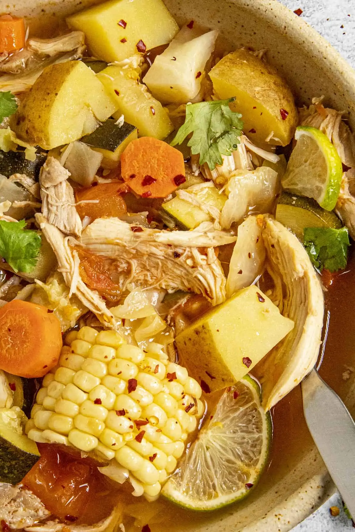Chunky Caldo de Pollo in a bowl with lots of chicken and vegetables