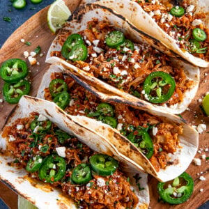 Chicken Tinga Tacos served on a wooden board