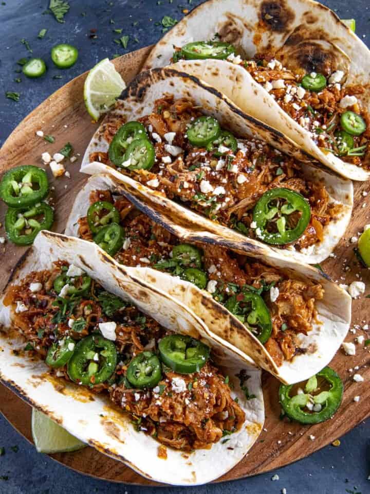 Chicken Tinga Tacos served on a wooden board