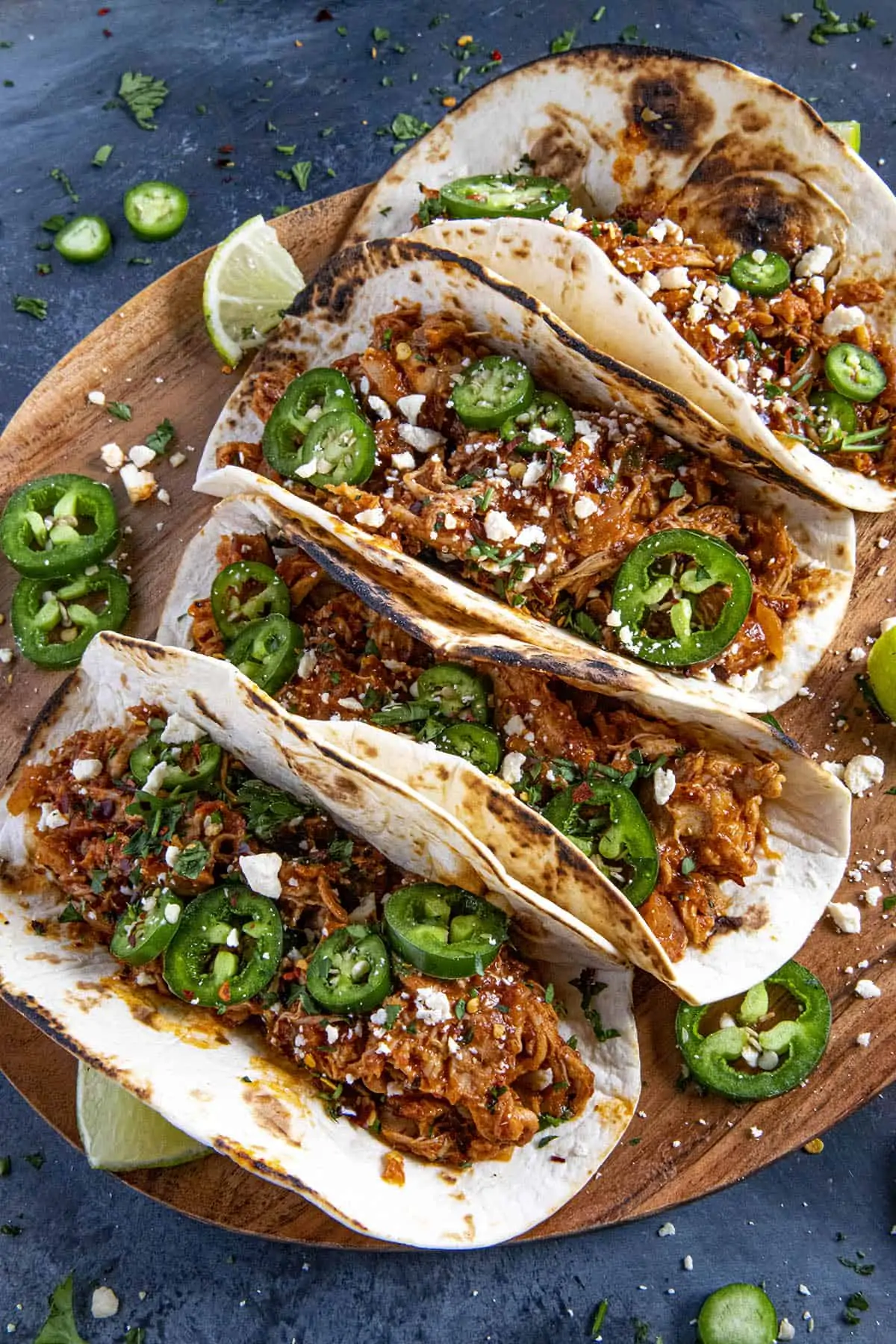 Chicken Tinga Tacos served on a wooden board