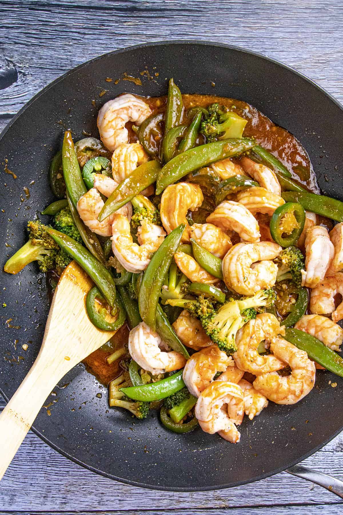 Mixing in the spicy shrimp stir fry ingredients together in a wok