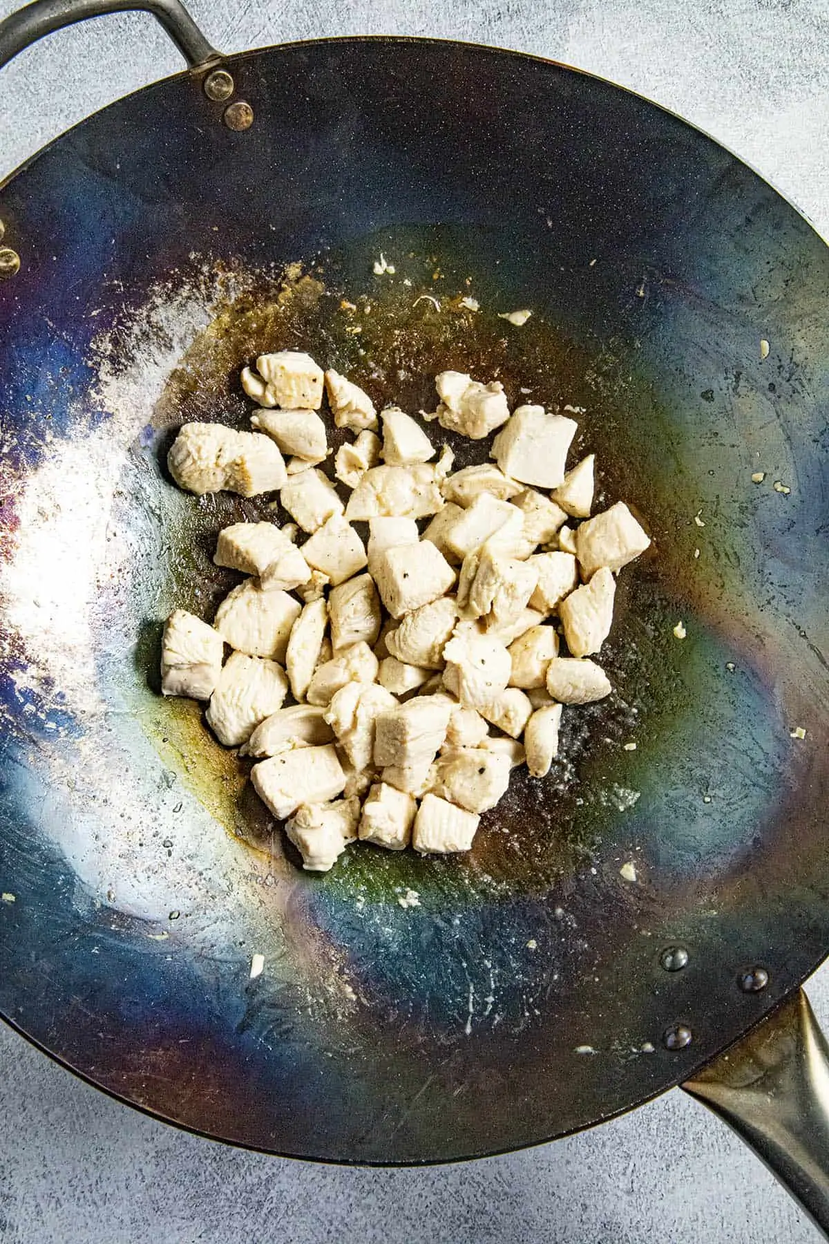 Stir frying the chicken in the hot wok