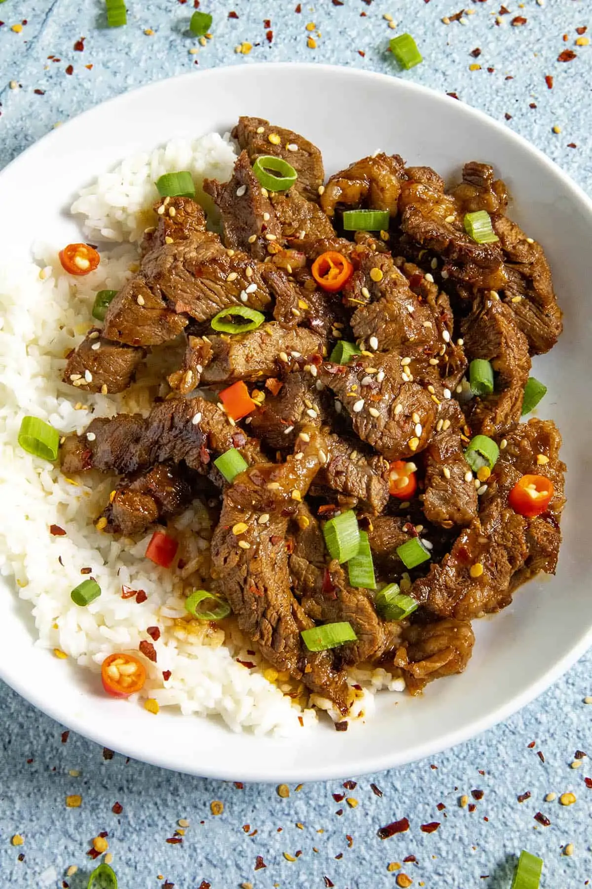 Bulgogi in a bowl, garnished with sesame seeds, green onion and peppers