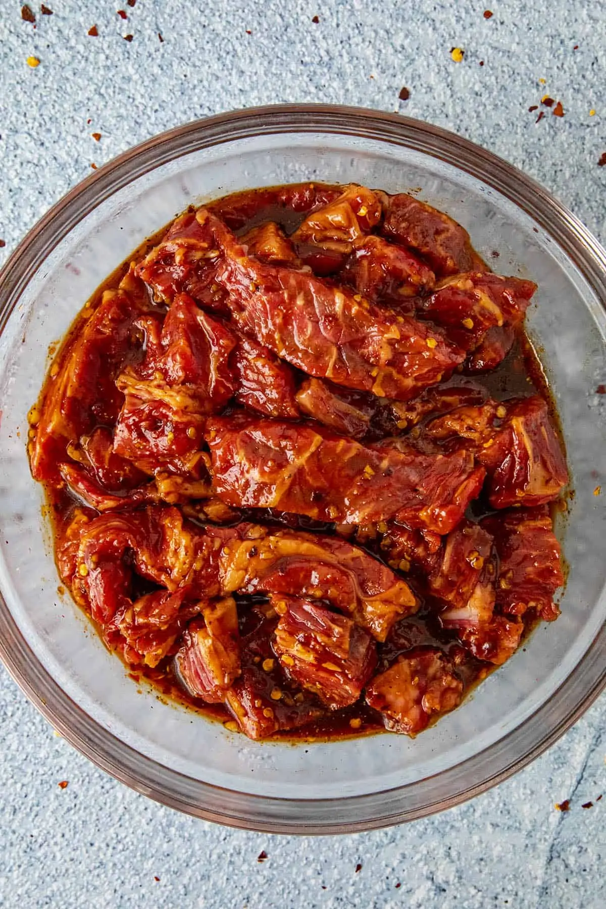 Sliced ribeye steak marinating in a bowl with bulgogi sauce