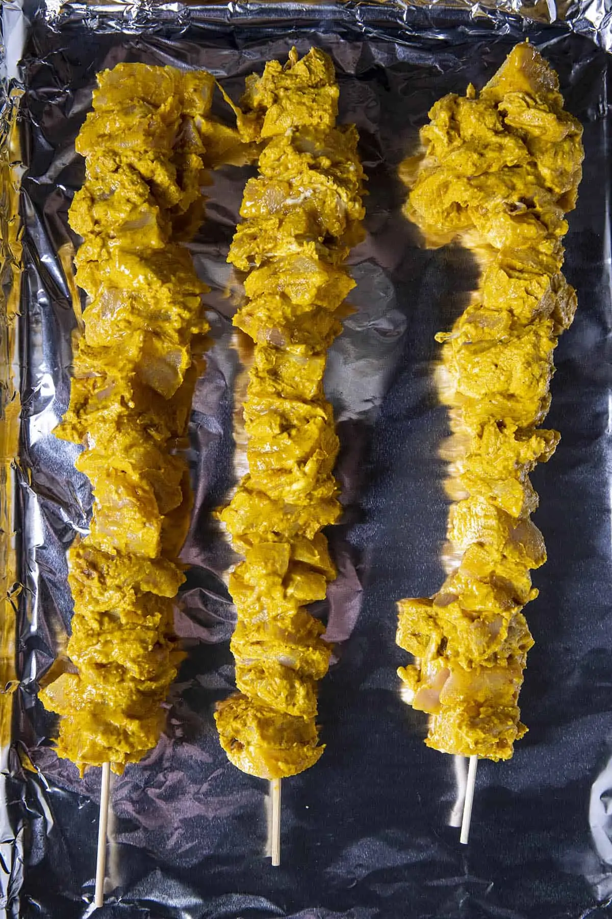 Yogurt marinated chicken on skewers, ready to bake