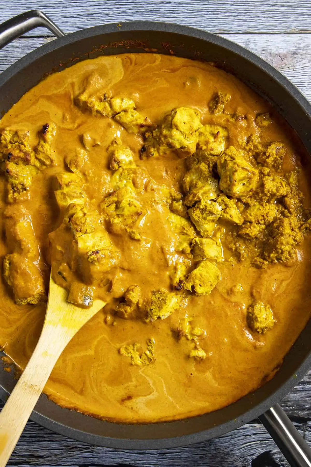 Stirring the chicken into the pan of simmering Chicken Tikka Masala