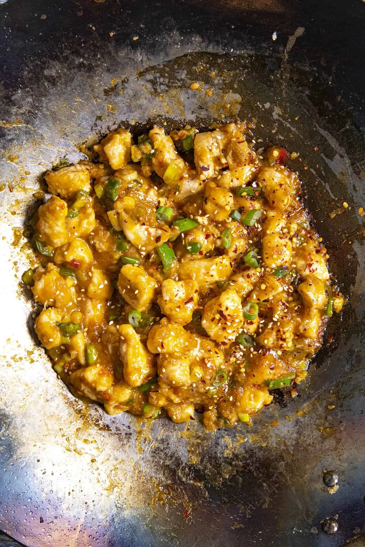 General Tsos Chicken in a wok with garnish.