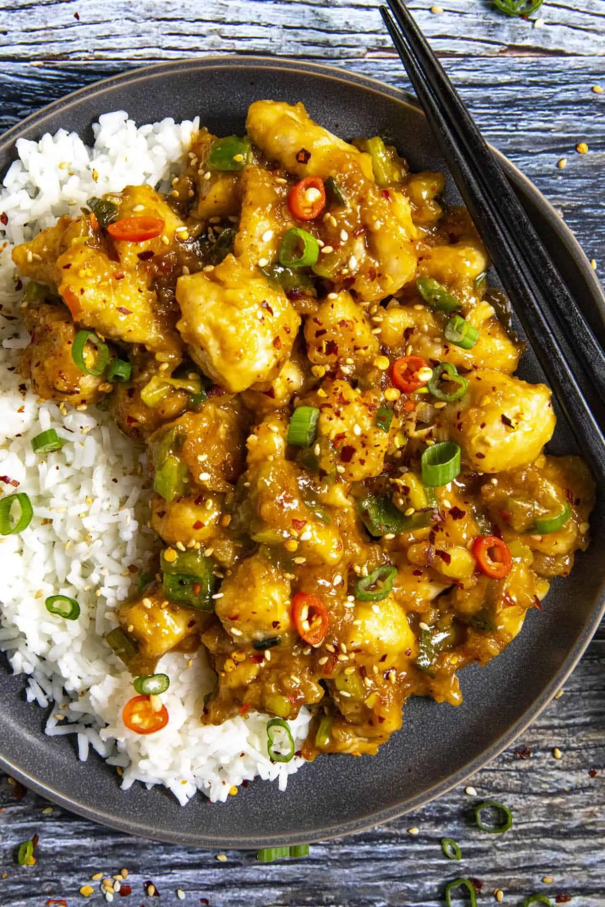 General Tsos Chicken on a plate with chopsticks.