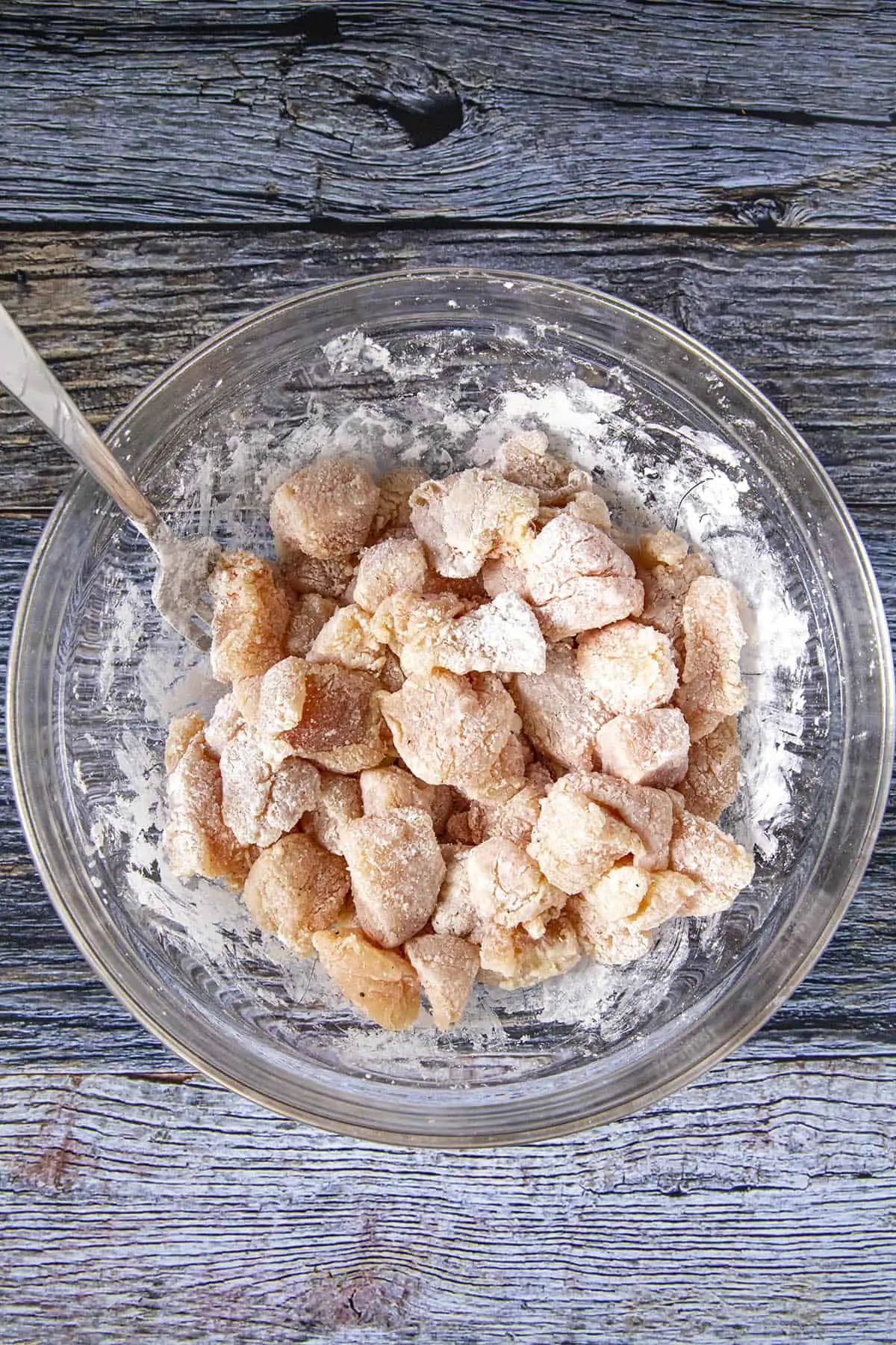 Coating chicken pieces with cornstarch.