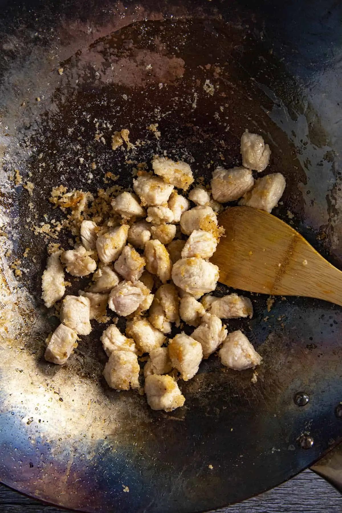 Stir frying the chicken in the wok to make General Tsos Chicken.