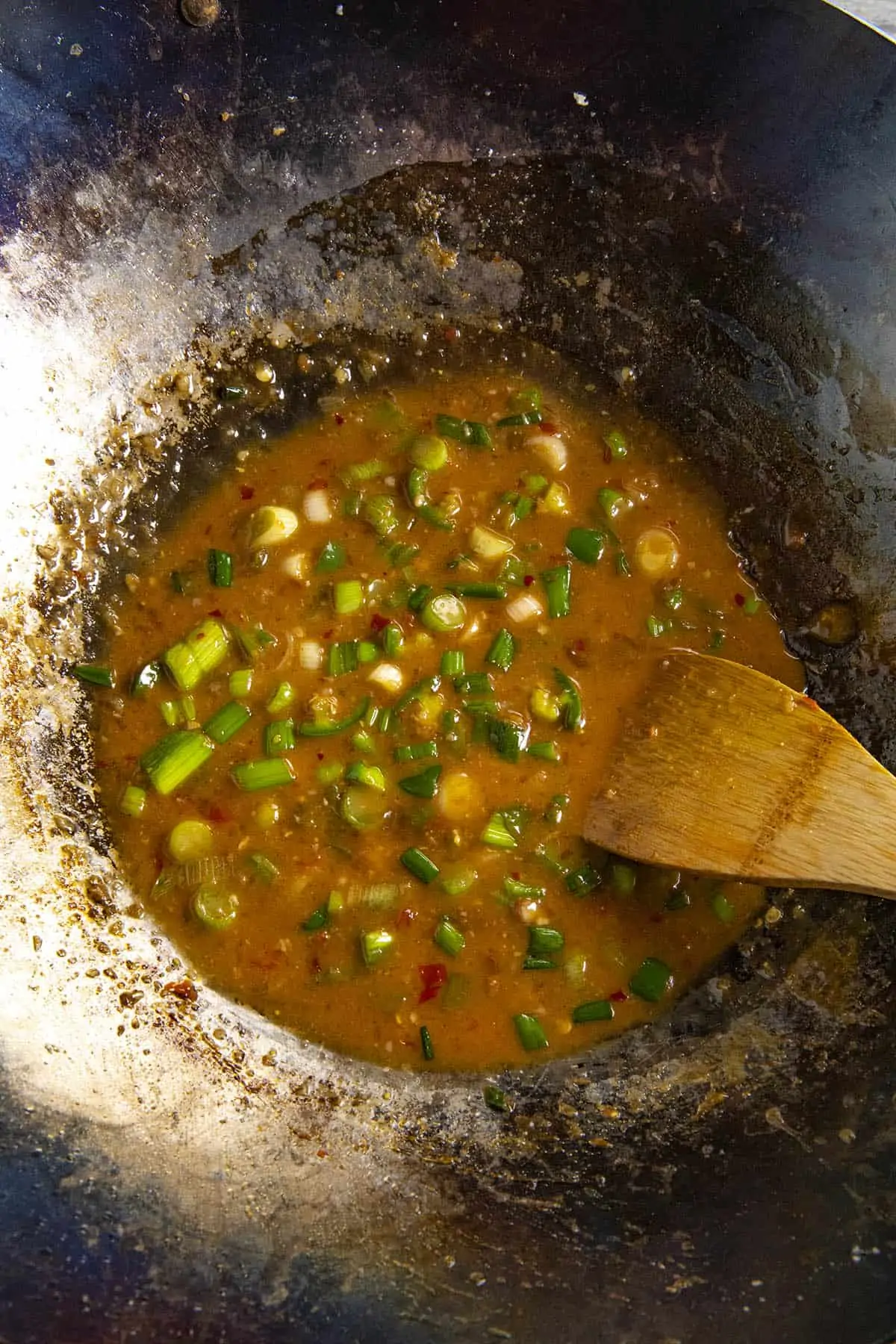 Stirring the General Tsos Chicken sauce into the wok.