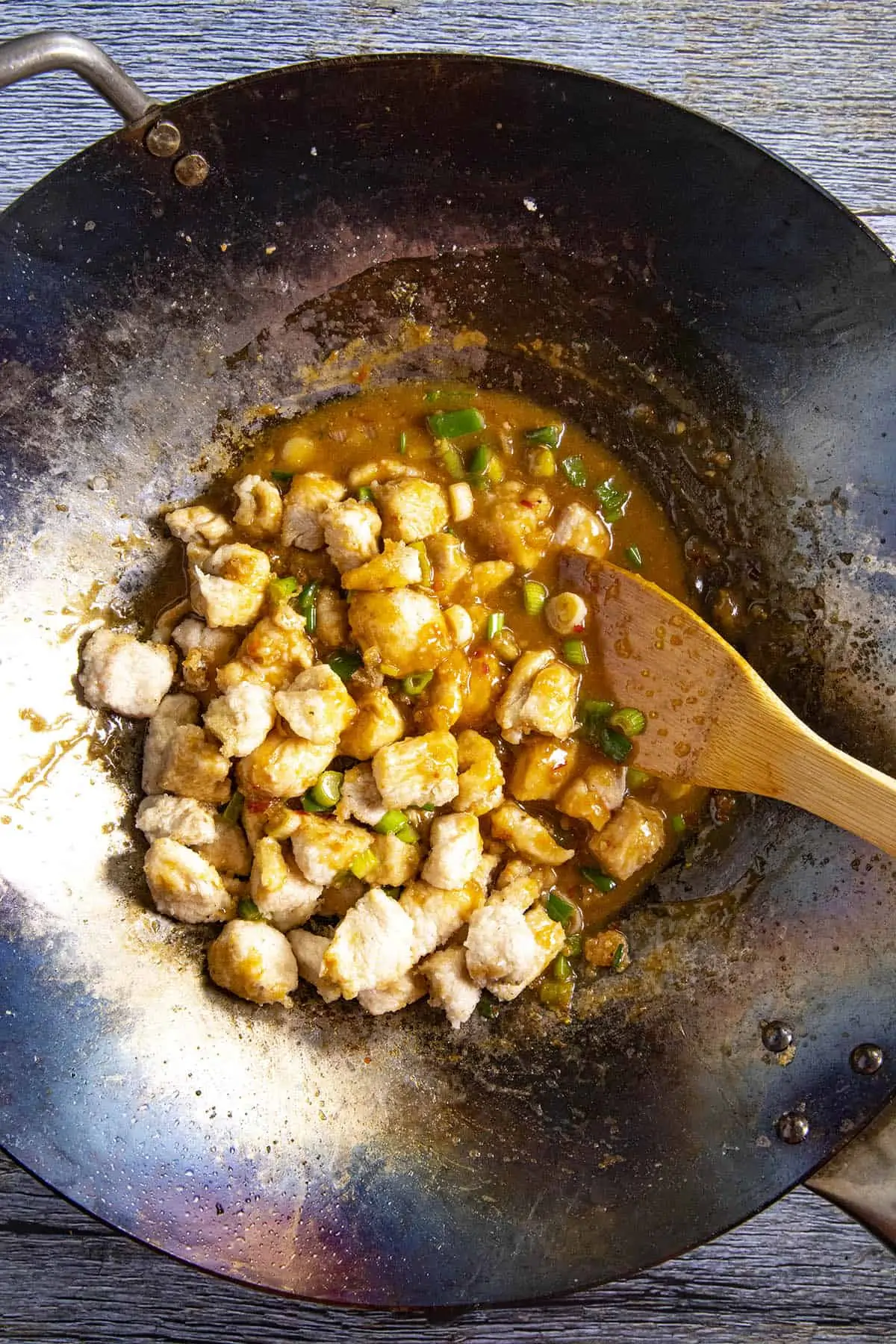 Stirring the chicken back into the wok.