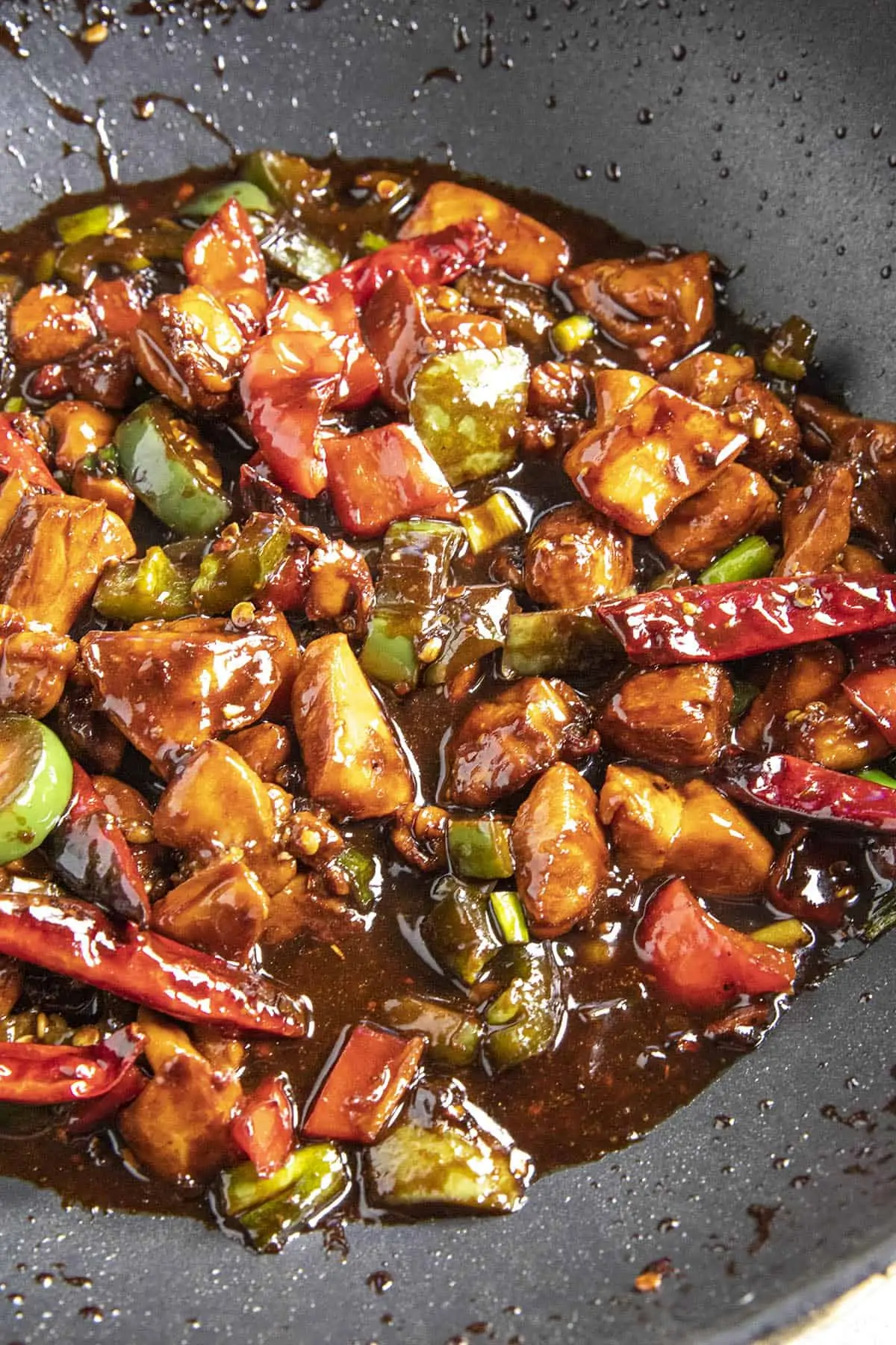 Simmering the Kung Pao Chicken in a pan with sauce