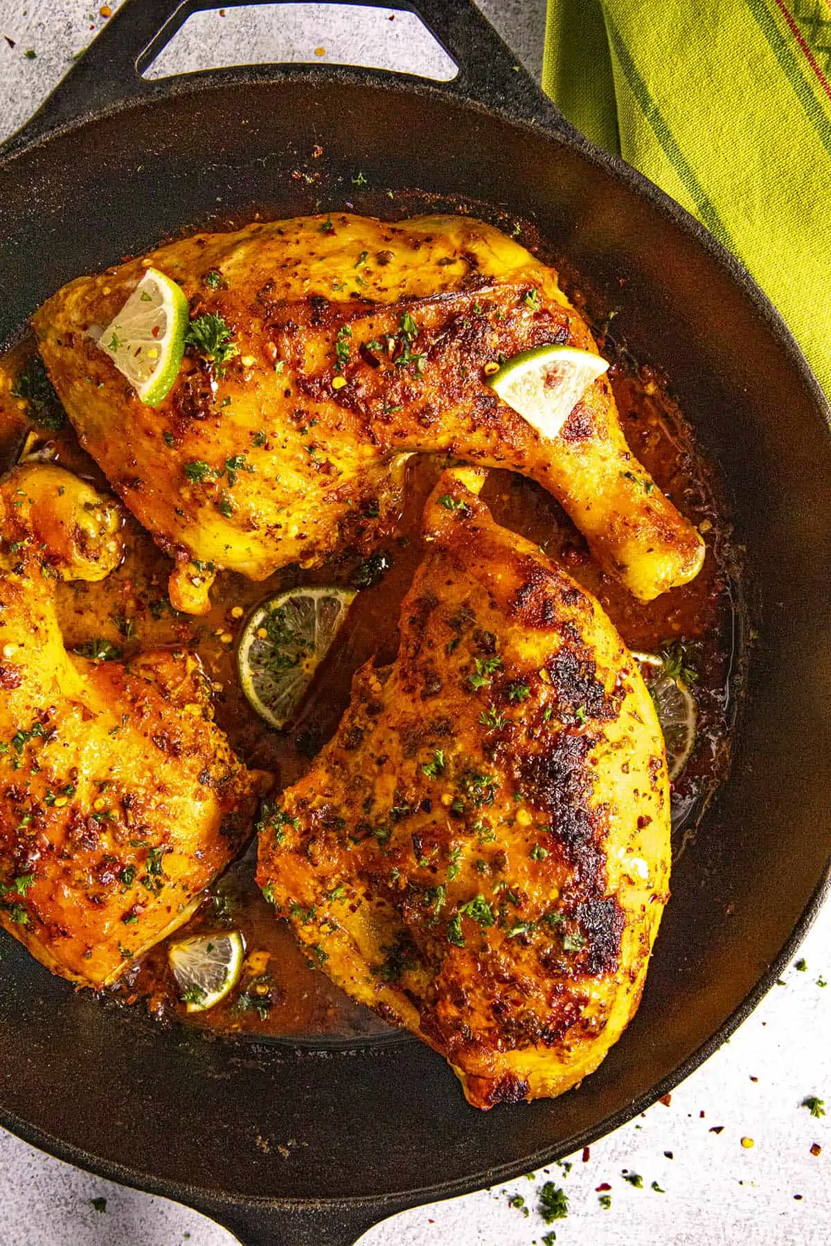 Moist and juicy Pollo Asado (Mexican roast chicken) garnished with lime wedges