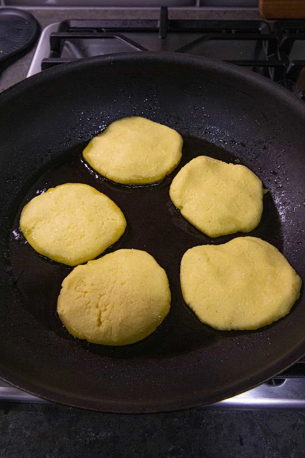 Arepas cooking in a hot pan