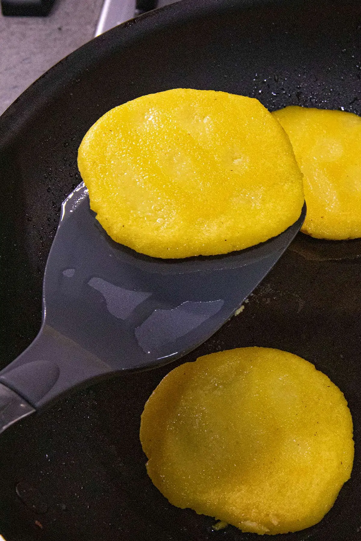 Mike flipping an arepa in a pan