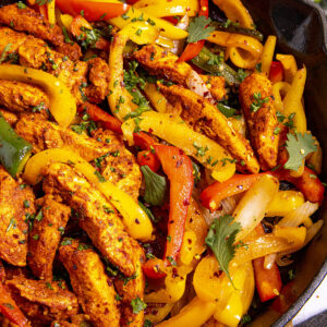 Delicious Chicken Fajitas in a hot pan with lots of garnish