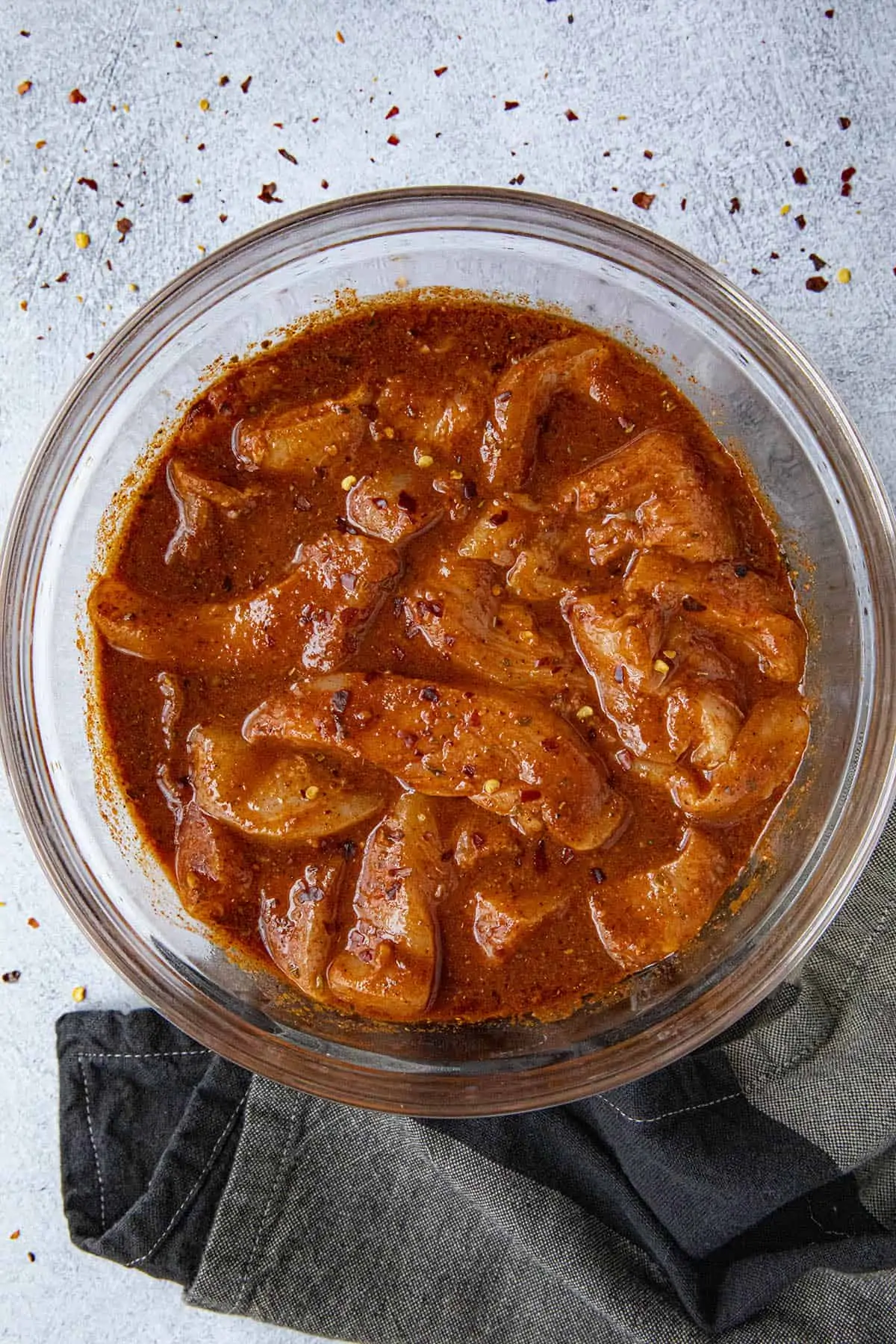 Slices of chicken marinating in a bowl for fajitas