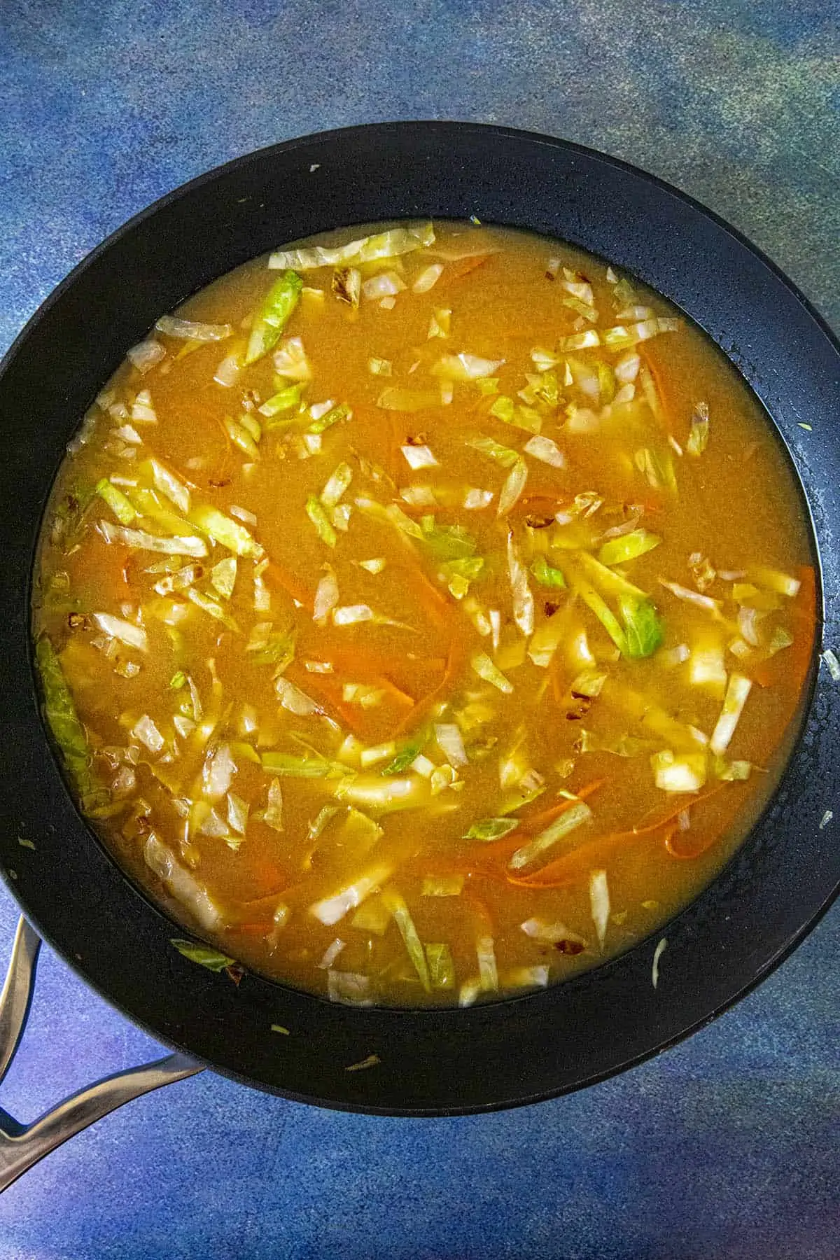 Adding seasoned broth to the pot for miso ramen