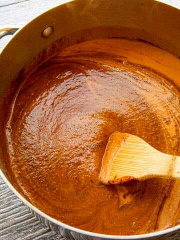 Swirling chocolate into the pot of mole sauce