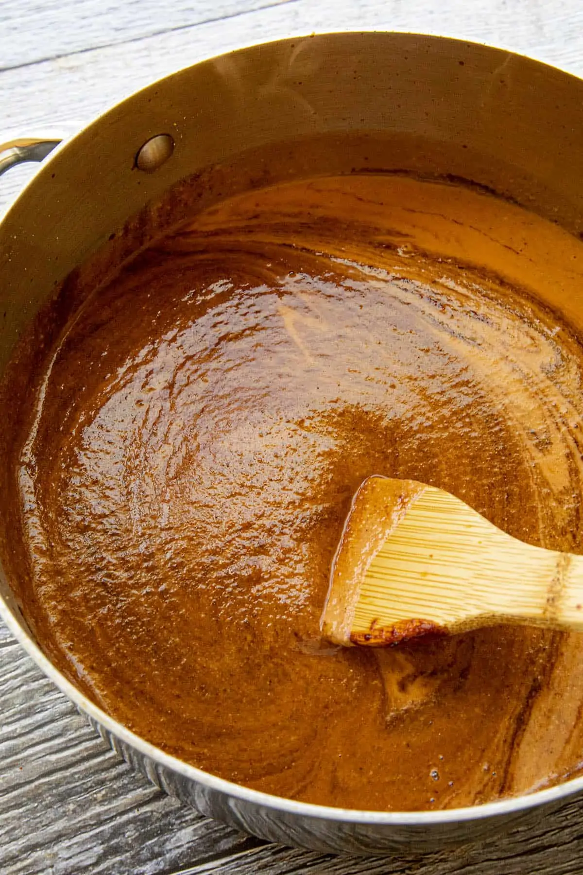 Swirling chocolate into the pot of mole sauce
