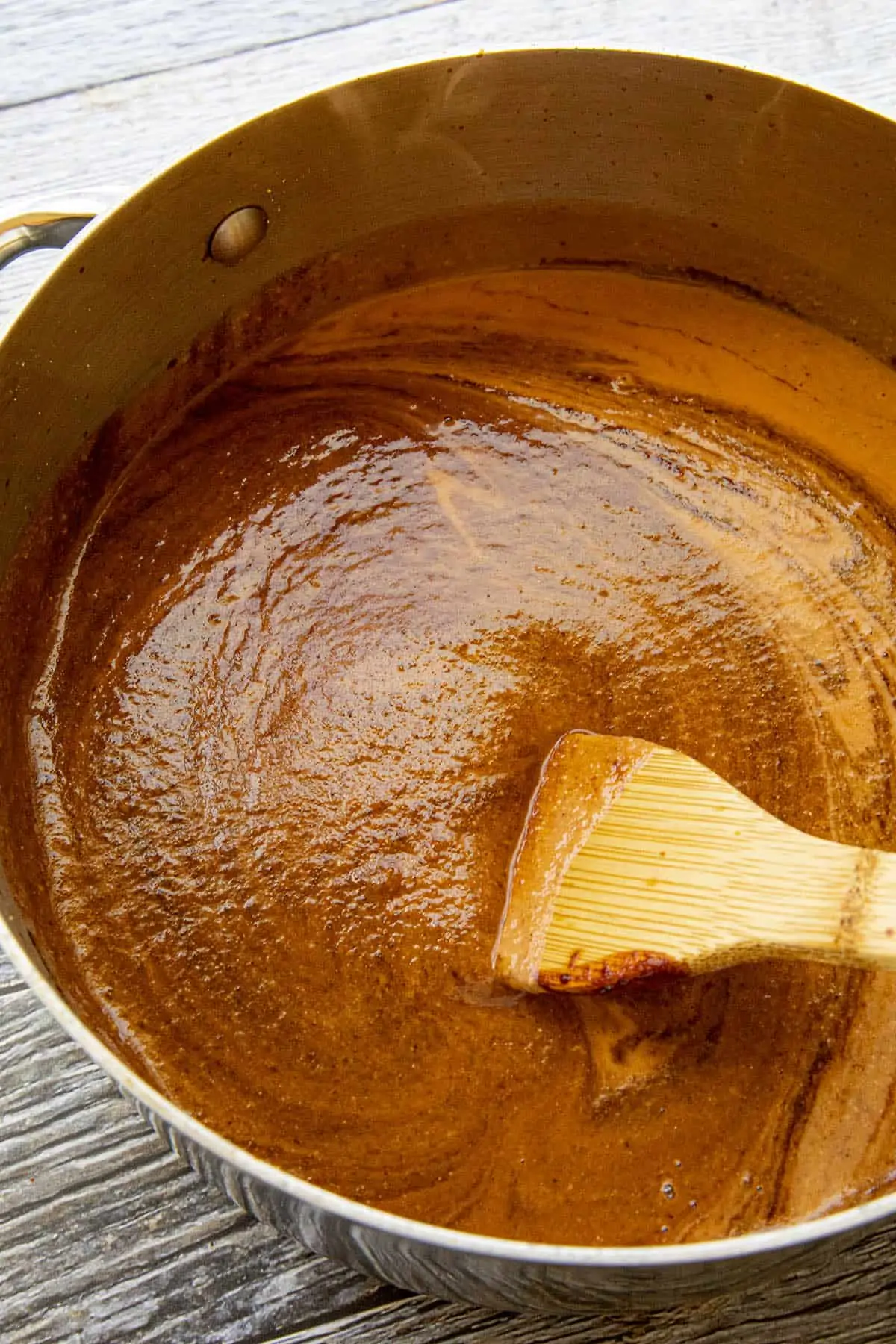 Swirling chocolate into the pot of mole sauce.