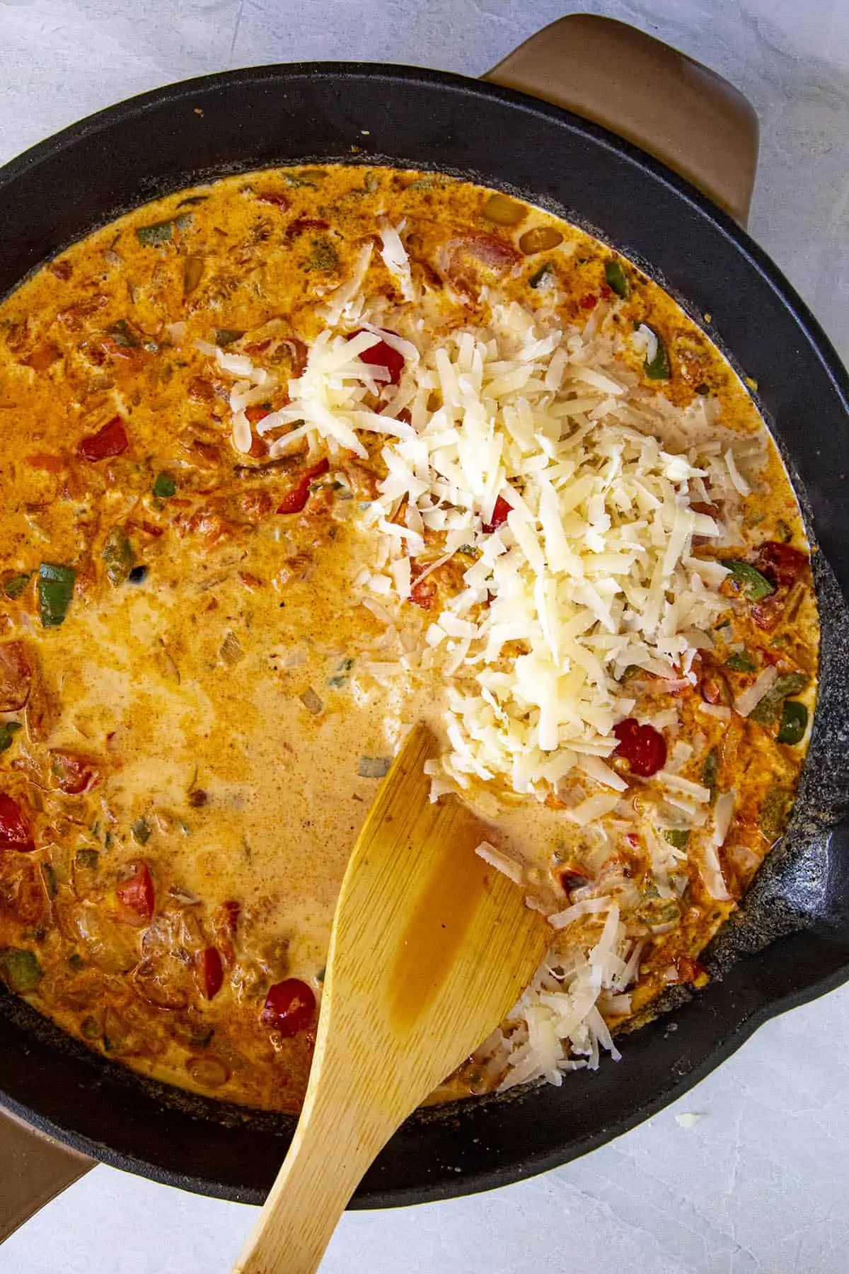 Stirring cheese into the pan to make queso dip.