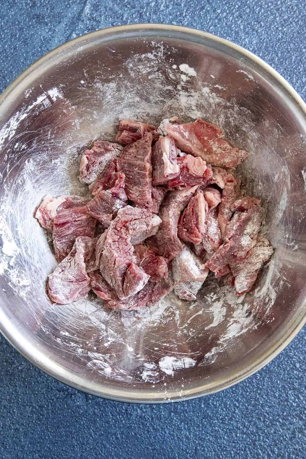 Coating strips of beef in corn starch.