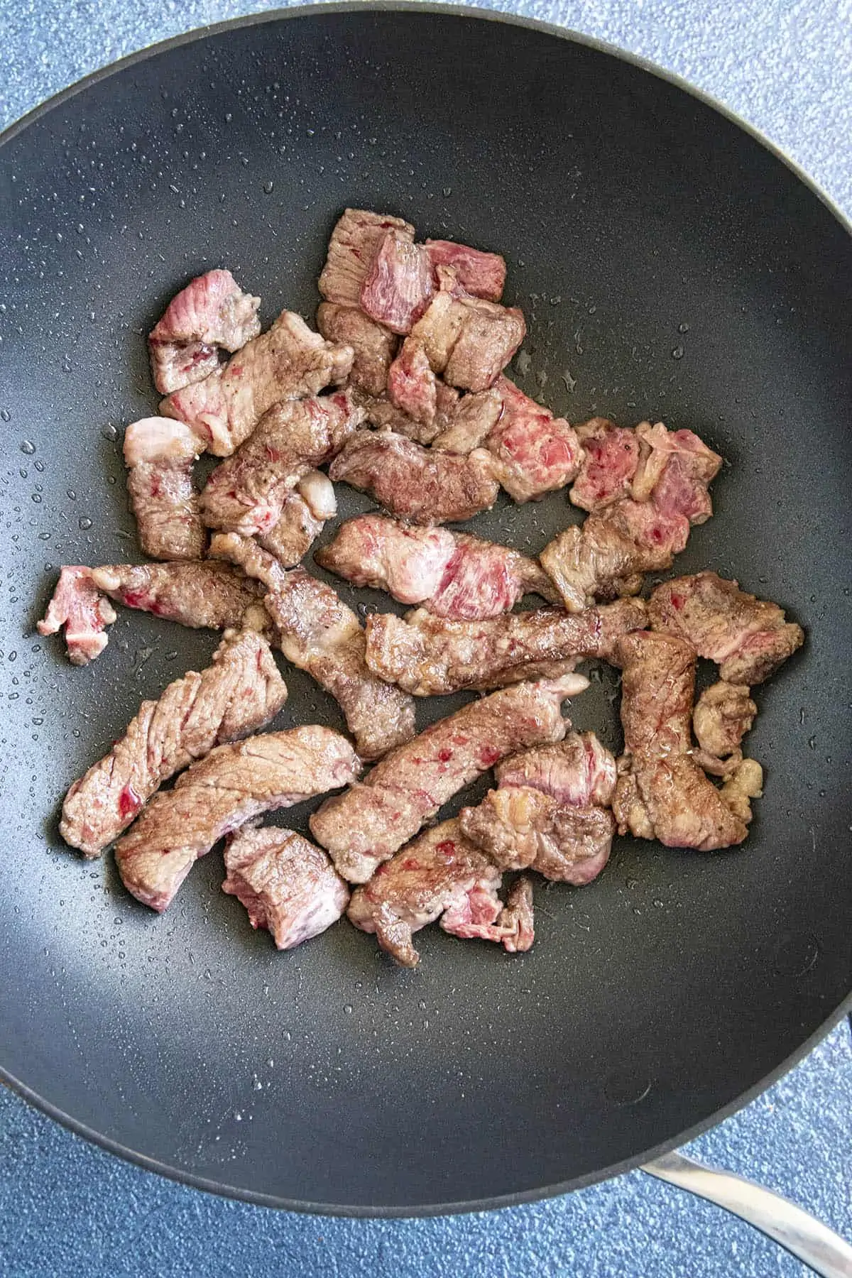 Searing strips of beef ribeye to make beef stir fry.