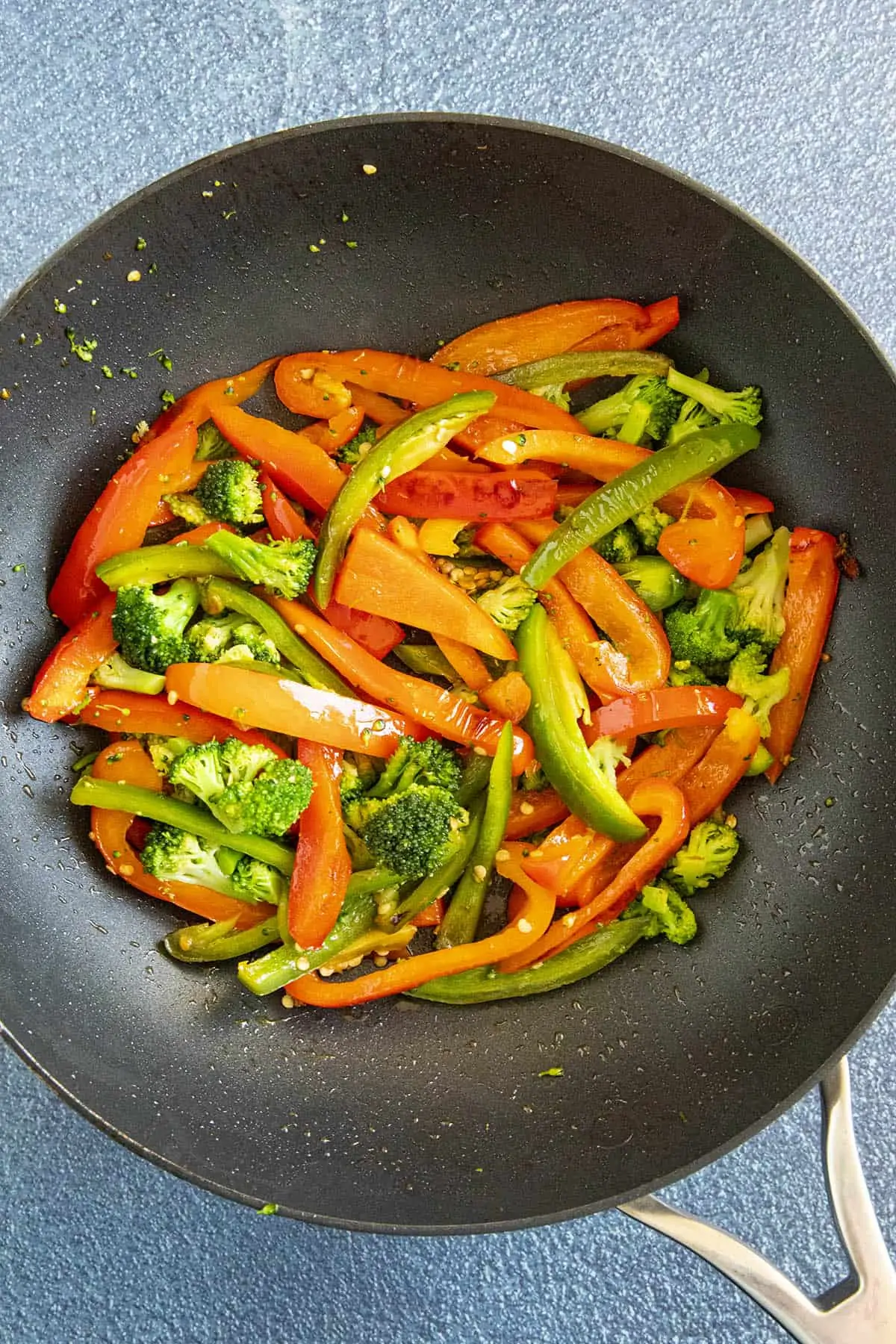 Searing peppers and broccoli into a hot pan.