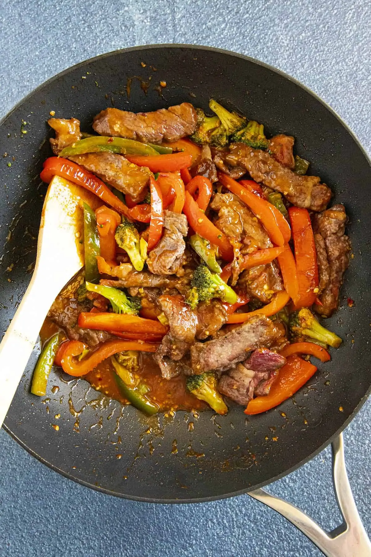 Stirring the peppers and broccoli into the pan with the seared beef.